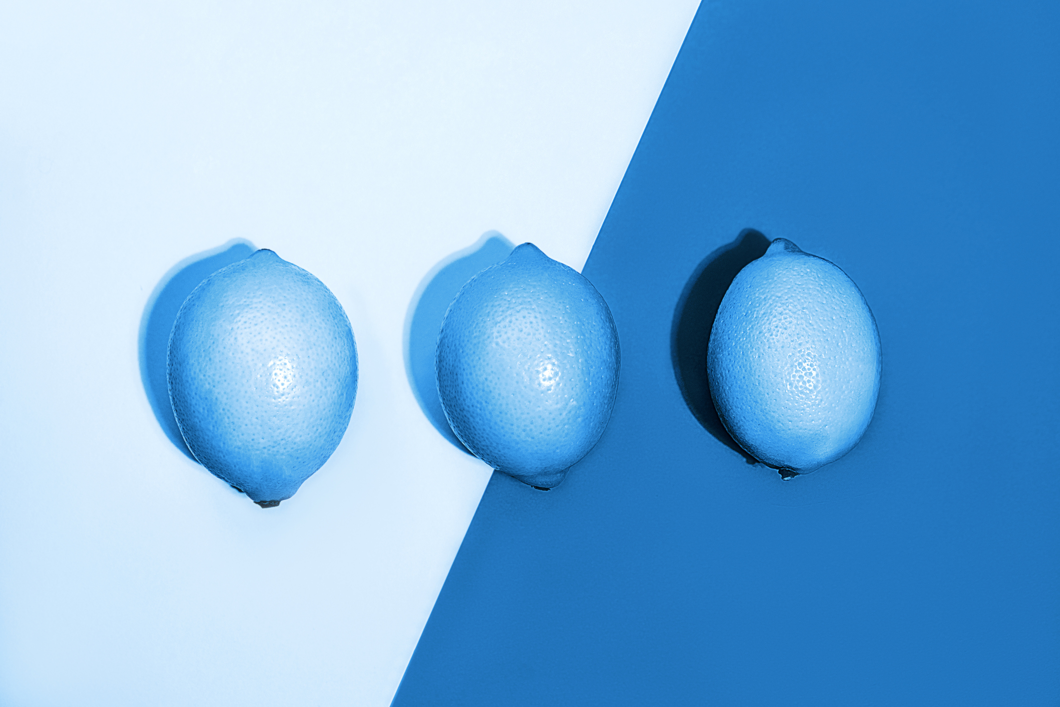 Classic Blue color of the Year 2020 inscription. Gradient colors palette. Creative pattern made of lemons on classic blue background. Fruit minimal concept. Top view, flat lay, close up.